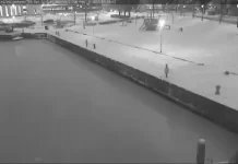 Webcam view of a boat gently floating in the water at Vollenhove Marina, surrounded by calm waves and clear skies.