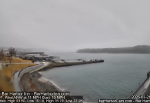 Live webcam view from Bar Harbor Inn showing a serene body of water with a wooden pier extending into it.