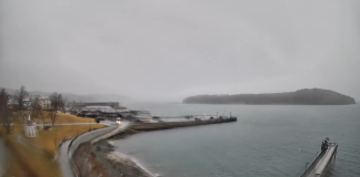 Live webcam view from Bar Harbor Inn showing a serene body of water with a wooden pier extending into it.