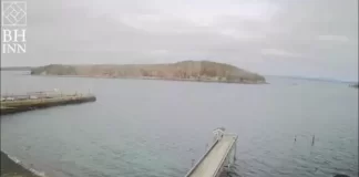 Live webcam view from Bar Harbor Inn showing a serene body of water with a wooden pier extending into it.
